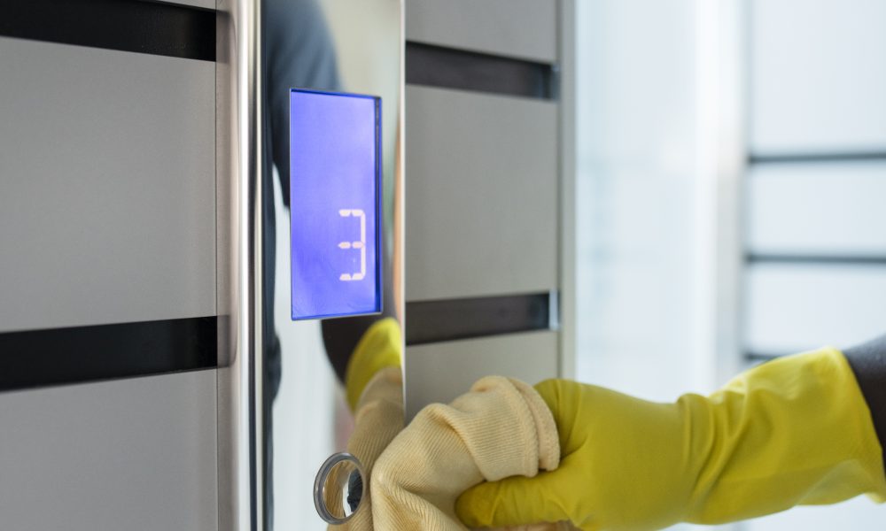 hand-cleaning-elevator-buttons-with-cloth